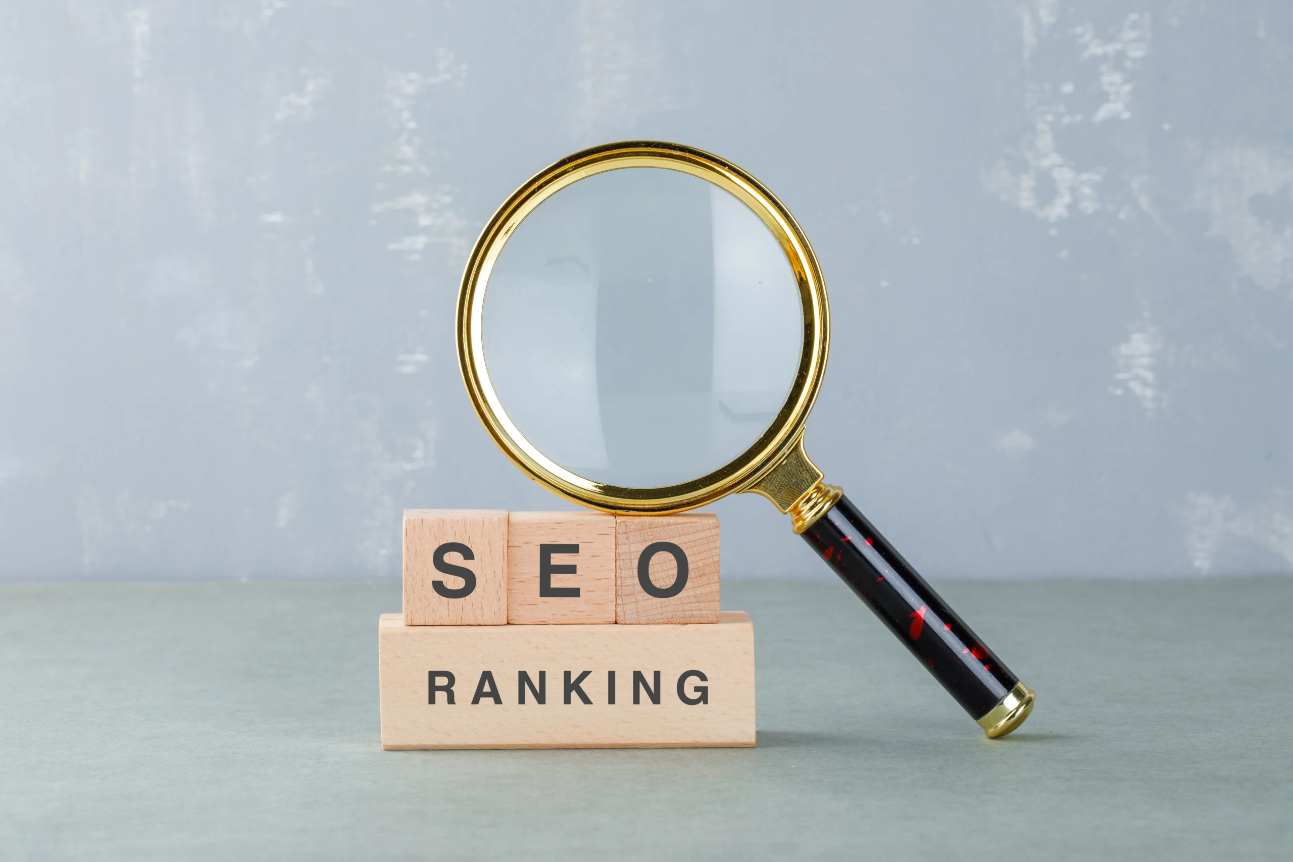 SEO Ranking – wooden blocks with 'SEO' and 'Ranking' text, with a magnifying glass symbolizing search engine optimization and website ranking